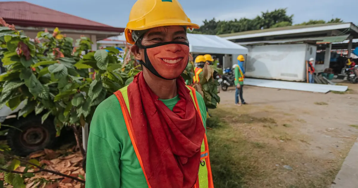 Smiling construction worker wearing a yellow hard hat and safety vest